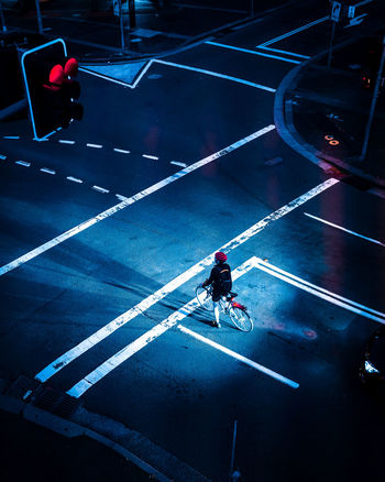 HIGH ANGLE VIEW OF MAN BICYCLING ON ROAD