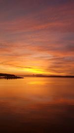 Scenic view of sea against dramatic sky during sunset