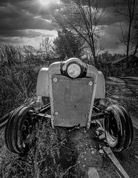 Abandoned vintage car on field against sky