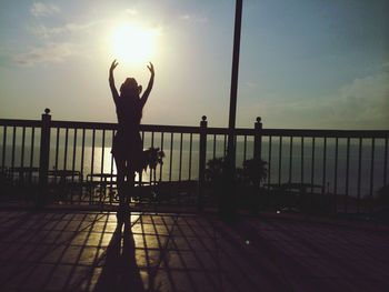Silhouette of woman against sky at sunset