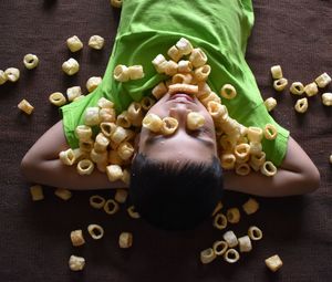 High angle view of boy with snacks on the carpet