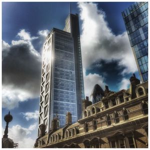 Low angle view of modern building against cloudy sky