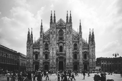 Crowd in front of milan cathedral against sky