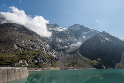 Scenic view of lake by mountains against sky