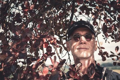 Portrait of man wearing sunglasses against trees