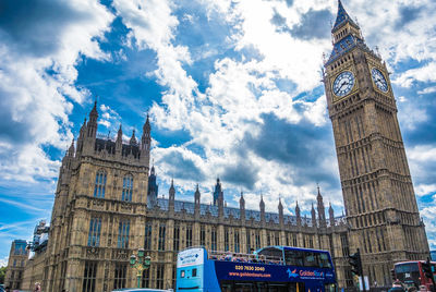 Low angle view of clock tower amidst buildings in city