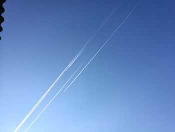 Low angle view of vapor trail against clear blue sky