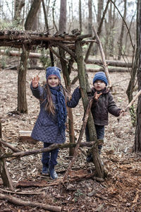 Full length of siblings standing in forest