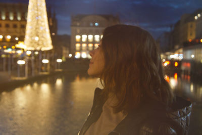 Portrait of woman in illuminated city at night