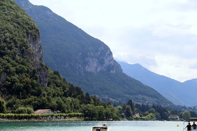 Scenic view of river by mountains against sky