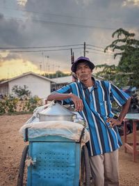 Man wearing hat standing by car