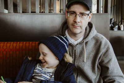 Father and son colouring in restaurant booth waiting for food