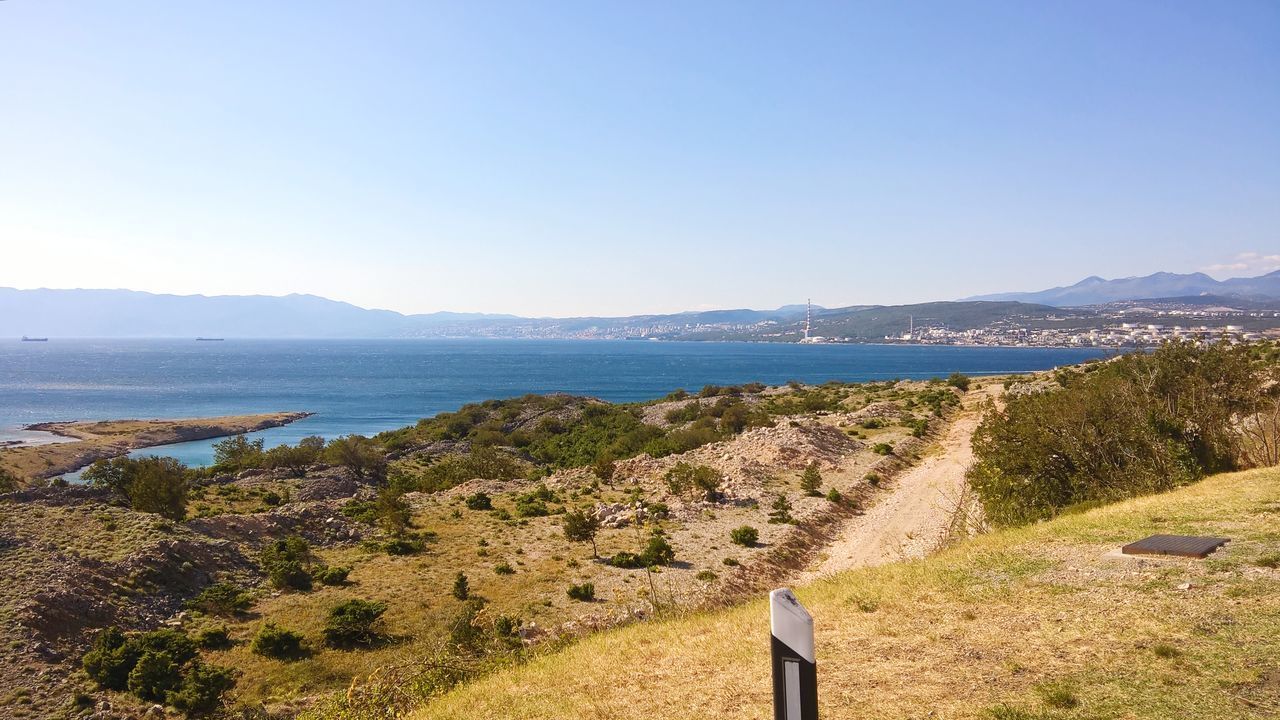 SCENIC VIEW OF SEA AND MOUNTAINS AGAINST CLEAR BLUE SKY