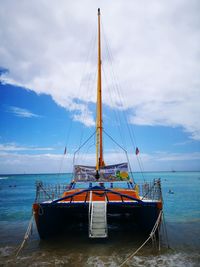 Sailboat moored on sea against sky