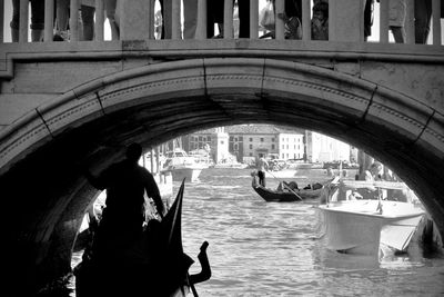 People on bridge over canal in city