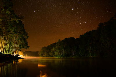 Scenic view of lake against sky at night