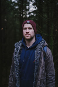 Portrait of young man standing in forest