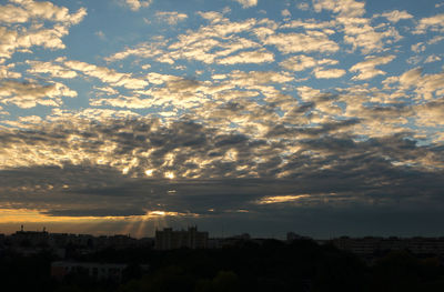 Scenic view of residential district against cloudy sky