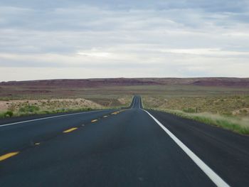 Empty road along countryside landscape