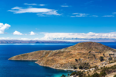 Scenic view of isla del sol at lake titicaca against blue sky