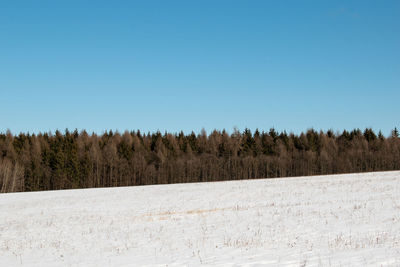 Snow covered landscape against clear sky