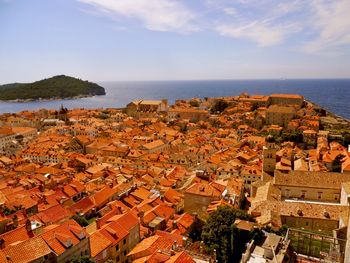 High angle view of town by sea against sky