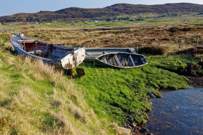 View of abandoned car on field