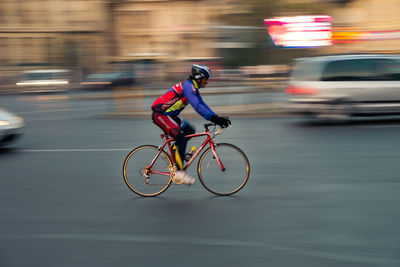 Side view of man riding bicycle on road