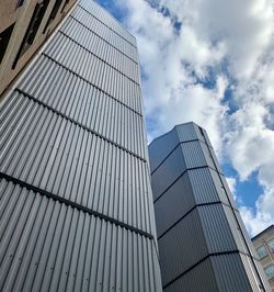 Low angle view of modern glass building against sky