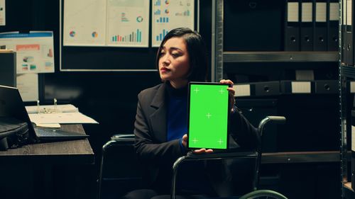 Portrait of young woman using laptop while sitting in train