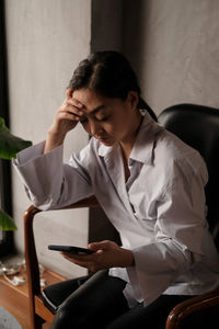 Depressed businesswoman using phone