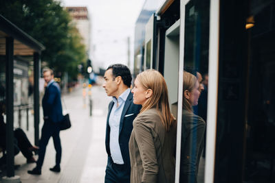 Mature business colleagues disembarking from cable car in city