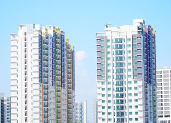 Low angle view of modern buildings against clear blue sky