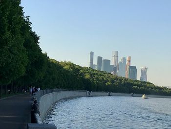 Scenic view of river by buildings against clear sky