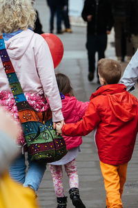 Mother with children walking on street in city