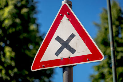 Close-up of railroad crossing sign against sky