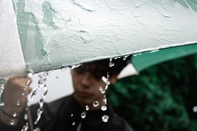 Man seen through wet window during rainy season