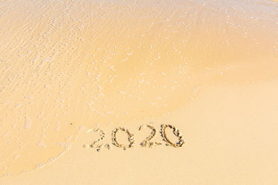 High angle view of text on heart shape on beach