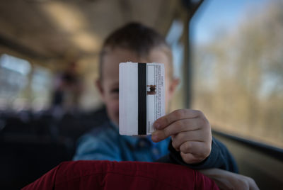 Boy holding ticket in train