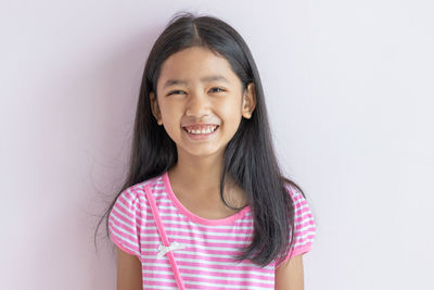 Portrait of a smiling girl against white background
