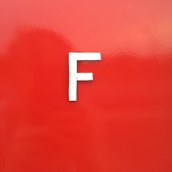 Close-up of letter f on red wall