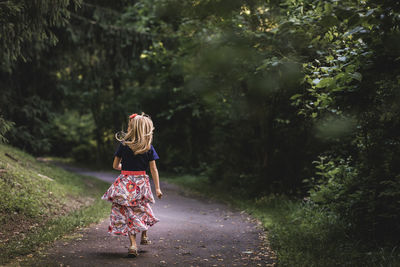 Rear view of a woman walking on road