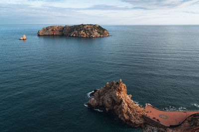 Rock formation in sea against sky