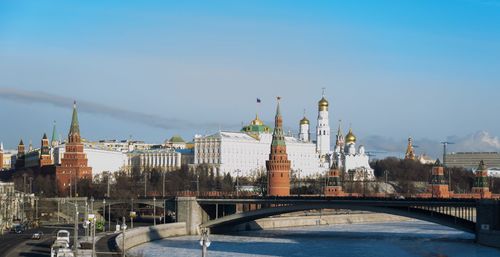 View of historic buildings in city against blue sky