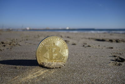 Close-up of coin on the beach