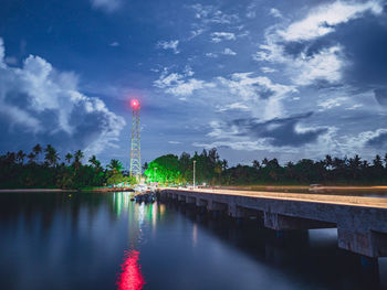 River by illuminated city against sky