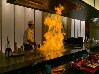 Fire in kitchen while chef preparing food in restaurant