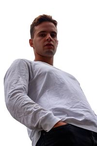 Portrait of young man standing against white background