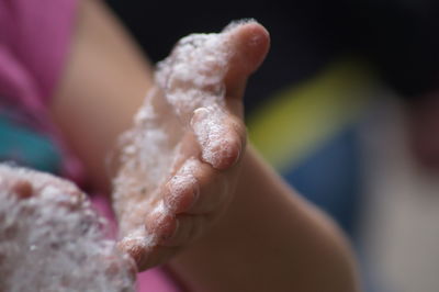 Midsection of woman with bubbles on hands