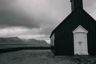 Built structure on field against cloudy sky